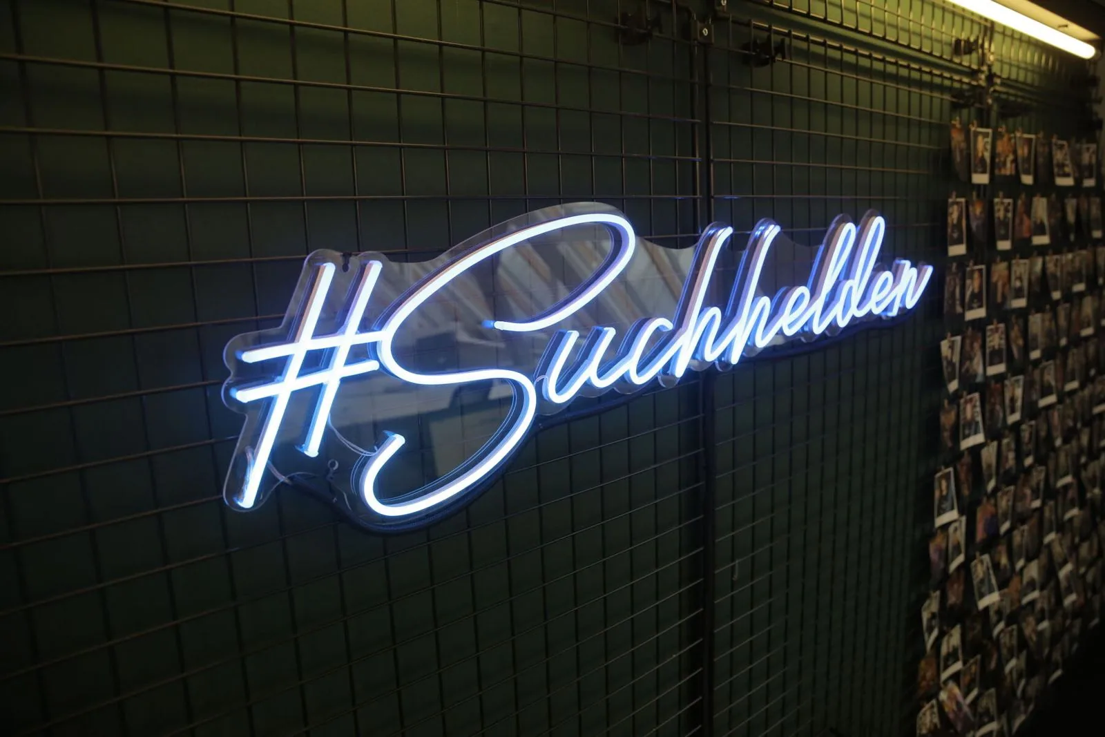Neonschriftzug „#Suchhelden“ neben der Polaroid-Wand im Suchhelden-Büro in Osnabrück Neonschriftzug „#Suchhelden“ neben der Polaroid-Wand im Suchhelden-Büro in Osnabrück