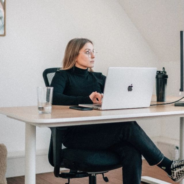 Mitarbeiterin arbeitet konzentriert am Laptop
